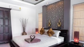 A modern bedroom with a large bed, dark wood headboard, and decorative wall panels. - Most beautiful Penthouse! (Muang Pattaya)