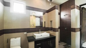 A modern bathroom with a white sink, dark cabinetry, and a large mirror. - Most beautiful Penthouse! (Muang Pattaya)
