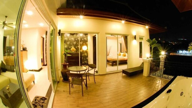 A modern house with a balcony, a dining area, and a large window. - Most beautiful Penthouse! (Muang Pattaya)