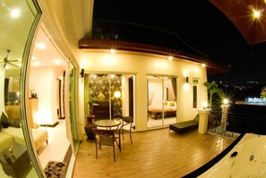 Une maison moderne dotée d’un balcon, d’un coin repas et d’une grande fenêtre.