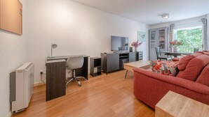 Ein modernes Wohnzimmer mit einer Couch, einem Schreibtisch, einem Stuhl und einem Essbereich.