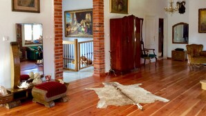 A spacious living room with hardwood floors, a brick archway, a large painting, and a chandelier. - Holiday Home Baltic Coast Near Beach (Mielno)