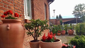 Terracotta pots with potted plants and flowers in front of a brick building. - Holiday Home Baltic Coast Near Beach (Mielno)