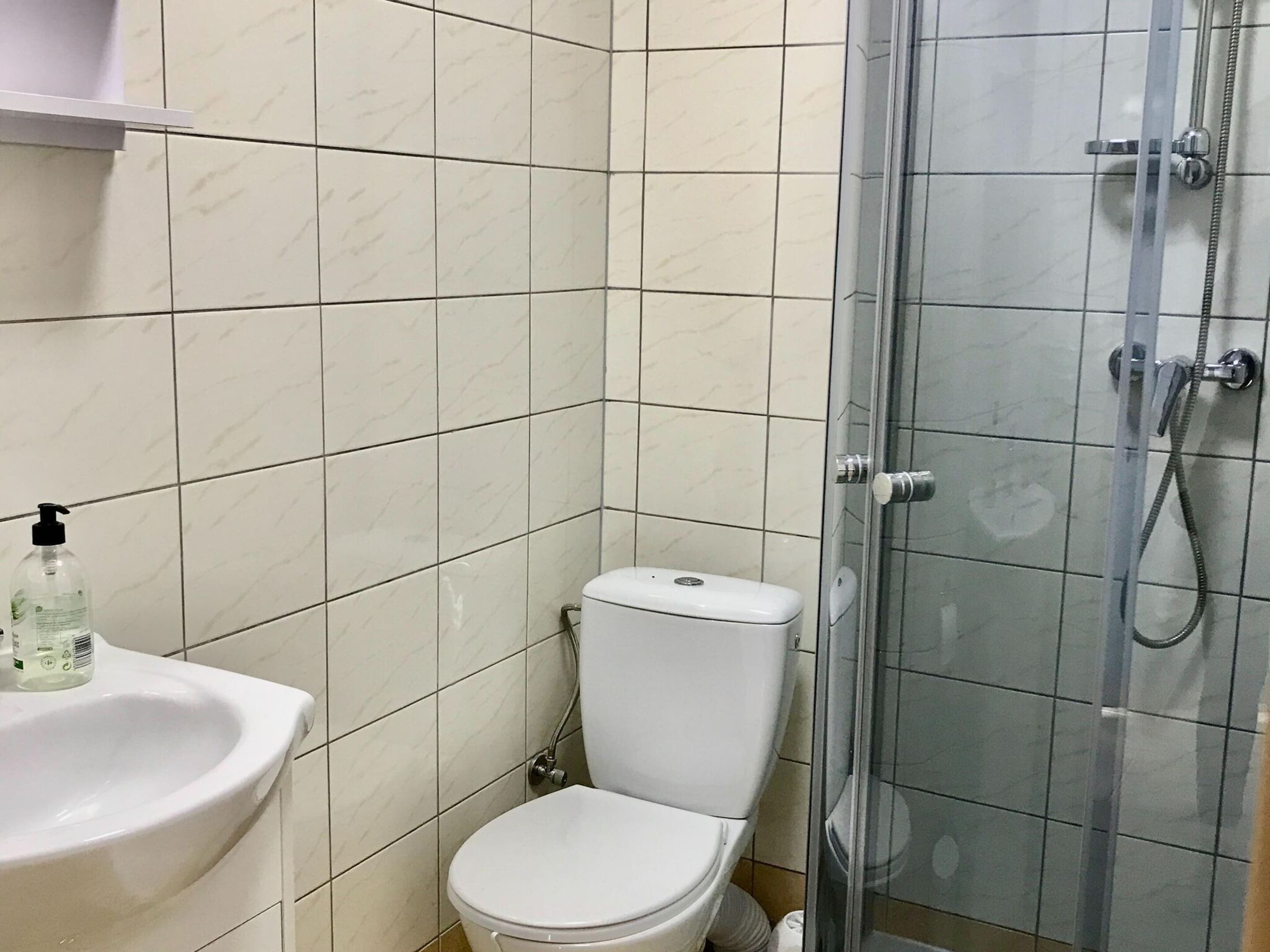 A bathroom with a toilet, sink, and shower.