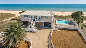 A beachfront house with a pool, a covered patio, and a two-story structure. - Welcome to One Fish Two Fish! (St. George Island)