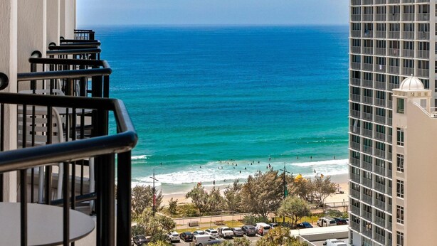 A balcony with a view of the ocean and a parking area with cars. - Surfers Paradise Beach & Ocean View Unit (Level 13) 
 (Surfers Paradise)