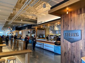 A spacious indoor area with a counter and seating, labeled "STRANG HALL".