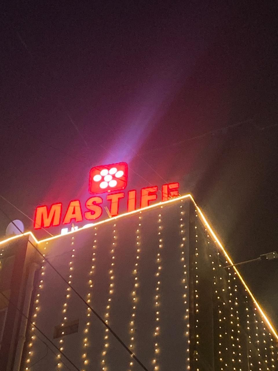 Um edifício com um letreiro chamativo 'MASTIFF' em letras vermelhas e um logotipo acima.