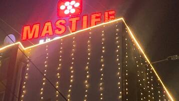 Un edificio con un letrero llamativo que dice 'MASTIE' y una serie de luces a lo largo de su fachada.