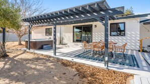 A modern outdoor patio with a pergola, outdoor seating, and a hot tub. - New Listing! Desert Oasis ~ Hot Tub (Twentynine Palms)