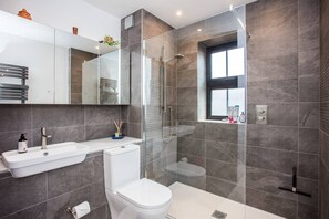 A modern bathroom with a glass-enclosed shower, a white sink, and a toilet. - Stunning 1 Bedroom Apartment Nearby Borough Market (London)