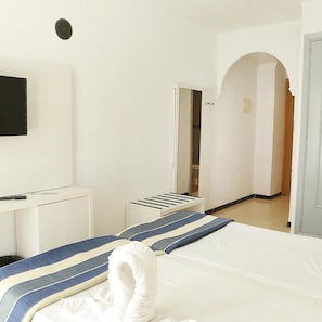 A hotel room with a bed, a desk, a television, and a wardrobe. - Hotel Cassandra Formerly Hotel Santa Monica (Llucmajor)