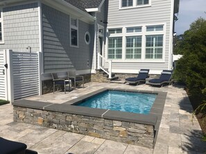 A swimming pool with stone edging, surrounded by lounge chairs and a stone wall. - 3.5 blocks to the beautiful Rehoboth Beach (Rehoboth Beach)