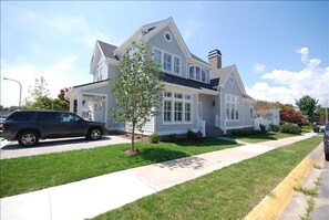 A two-story house with a front porch, a driveway, and a tree in the front yard. - 3.5 blocks to the beautiful Rehoboth Beach (Rehoboth Beach)