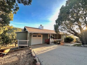 A single-story house with a garage, a covered porch, and a gravel driveway.