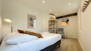 A neatly arranged bedroom with a bed, bedside lamp, and a wall-mounted shelf with decorative items.
