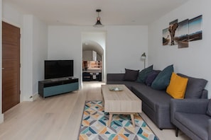 Departamento básico, varias camas | Área de sala de estar | Televisión