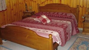 Un lit en bois avec une tête de lit, deux tables de chevet et un tapis à motifs.