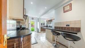 Una cucina moderna con isola a forma di curva, sgabelli da bar e vista sull'esterno.