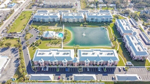 Vista aérea de un hotel con patio central, varias construcciones y una piscina.
