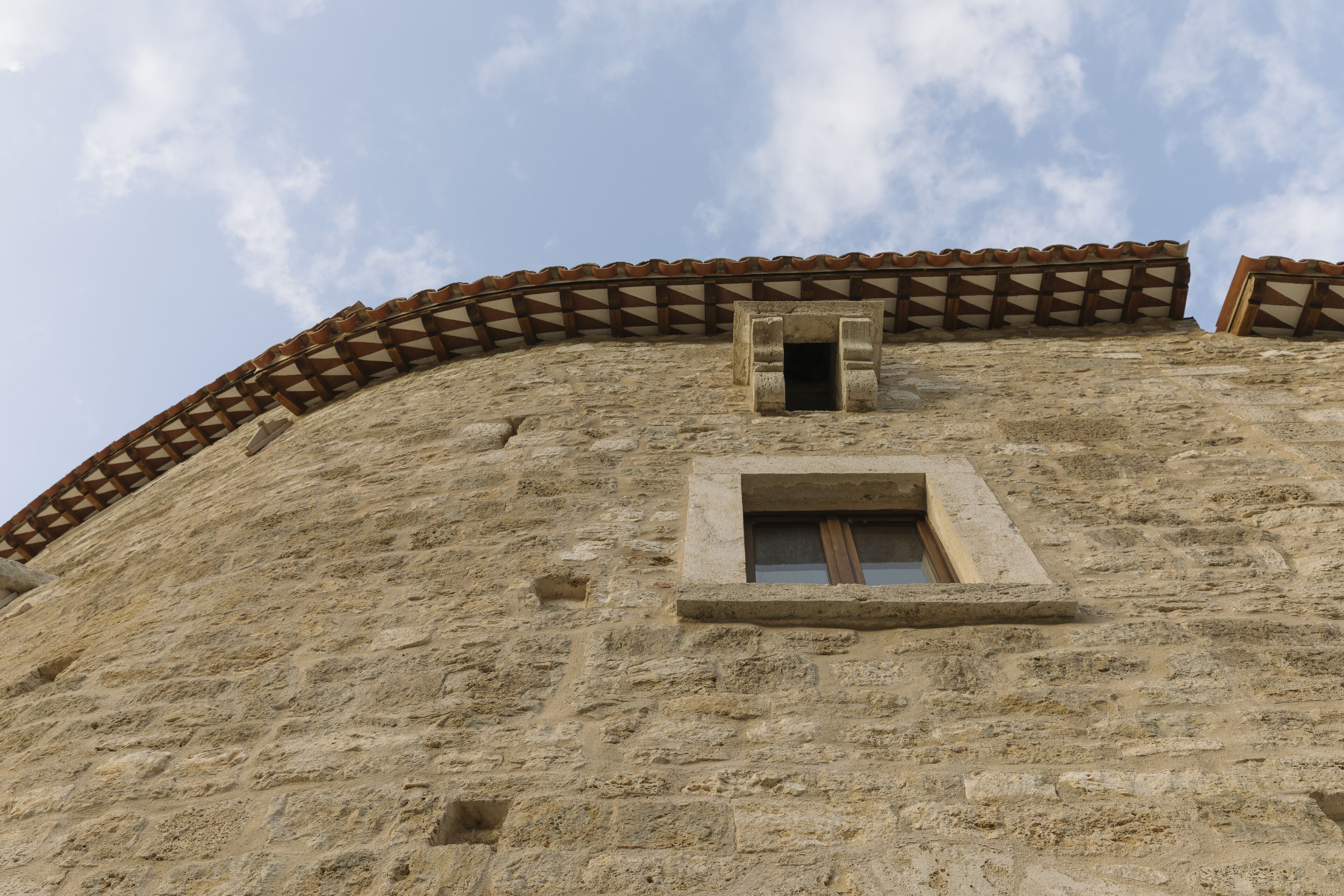 A stone building with a window and a door.