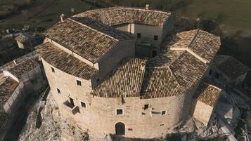 Vue aérienne d’un bâtiment historique en pierre, de forme circulaire, comprenant plusieurs niveaux et une cour intérieure.