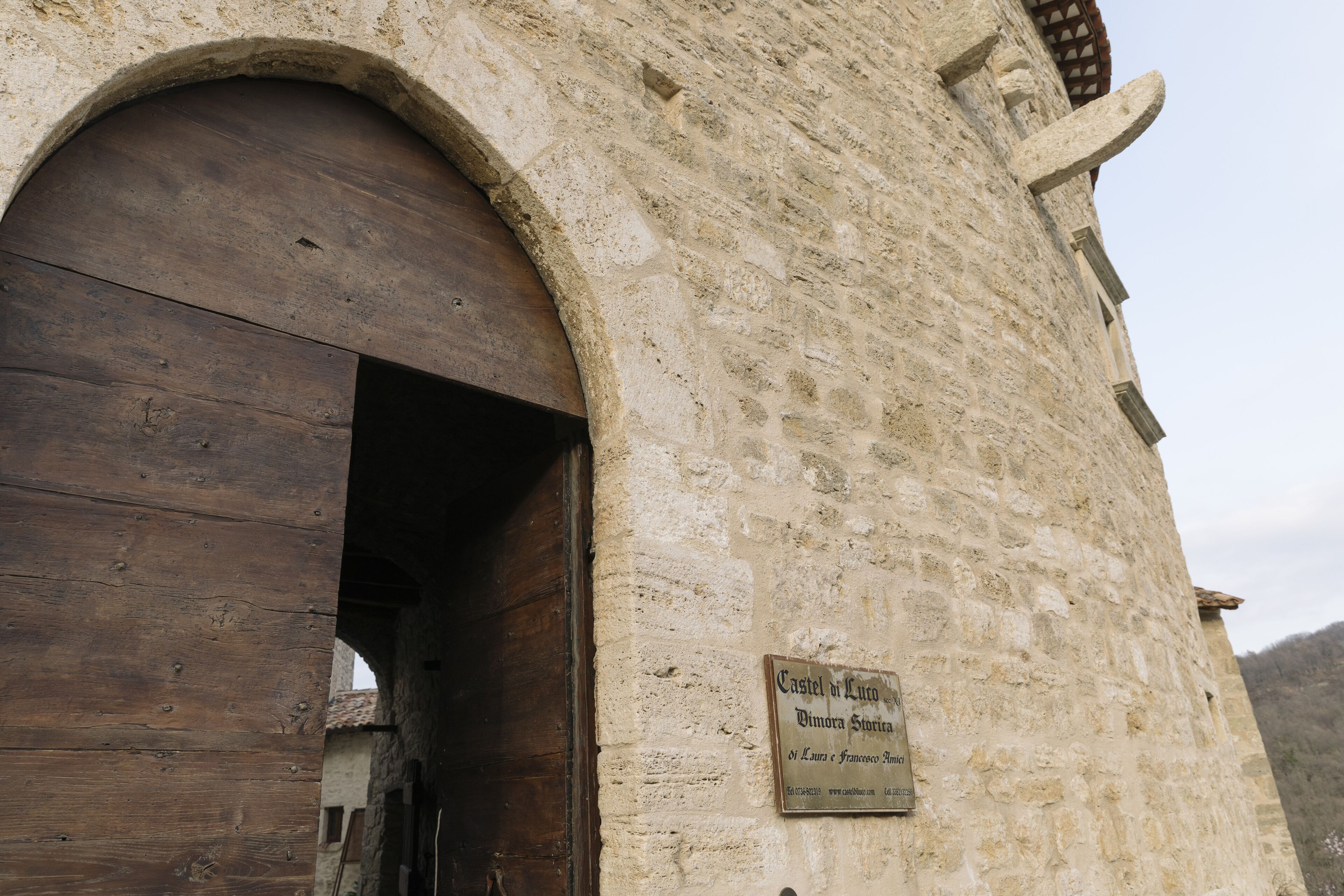 Un bâtiment en pierre avec une porte en bois et une enseigne sur laquelle on peut lire « Castel di Luso ».