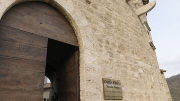 Un bâtiment en pierre avec une porte en bois et une enseigne sur laquelle on peut lire « Castel di Luso ».