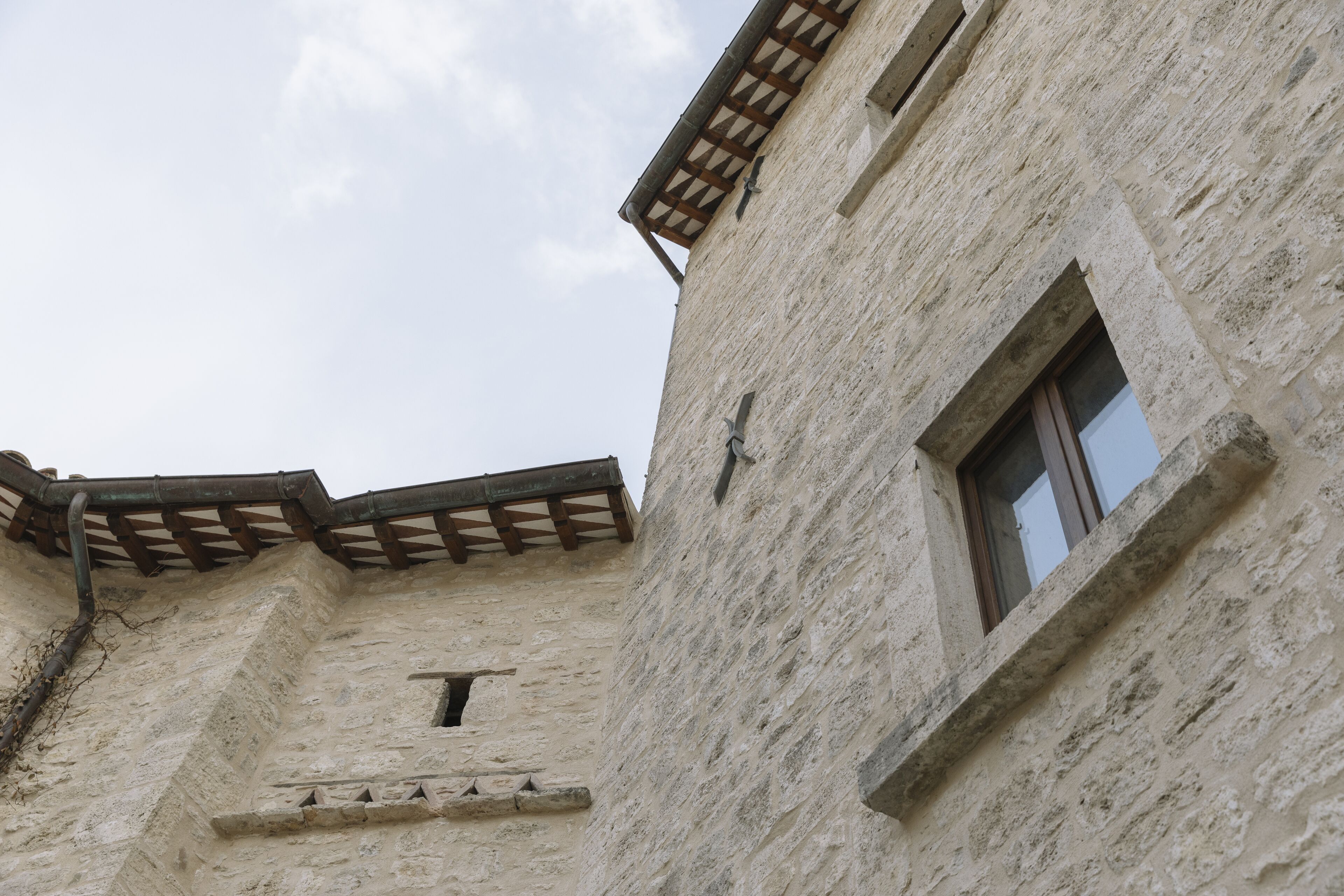 Un edificio de piedra con ventana y balcón de madera.