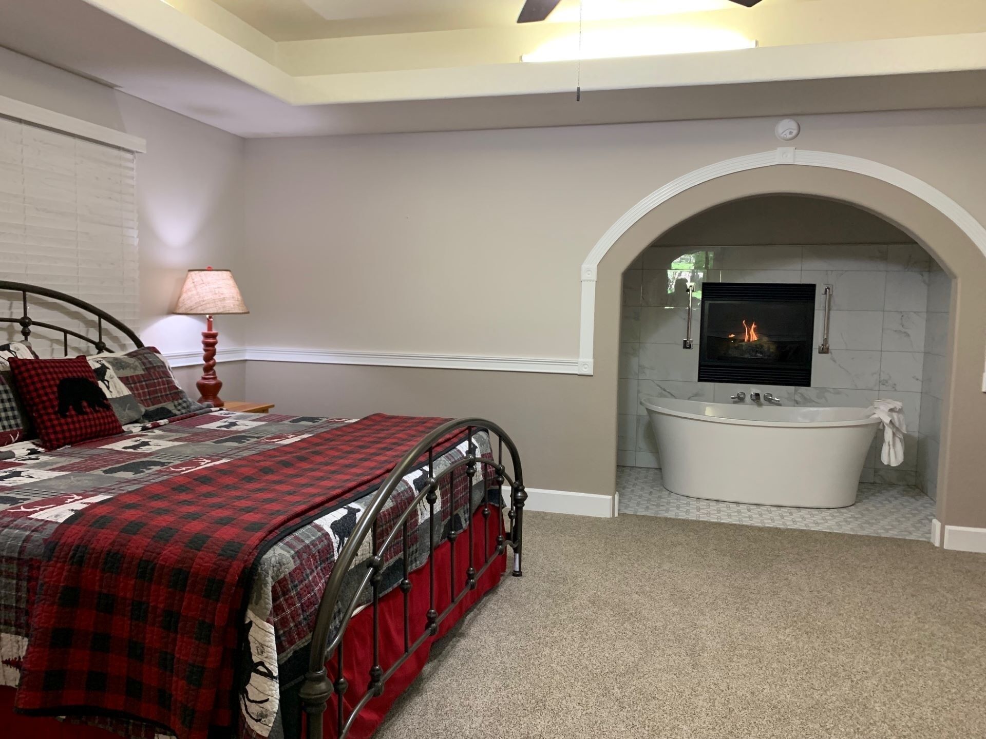 Un dormitorio con cama, chimenea y bañera.