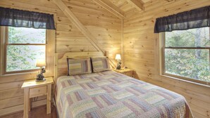 A cozy wooden cabin bedroom with a bed, two bedside tables, and two windows with curtains. - Er91 - Eagle's Beauty - Great Location - Close To All The Action! 2 Bedroom Cabin by RedAwning (Pigeon Forge)