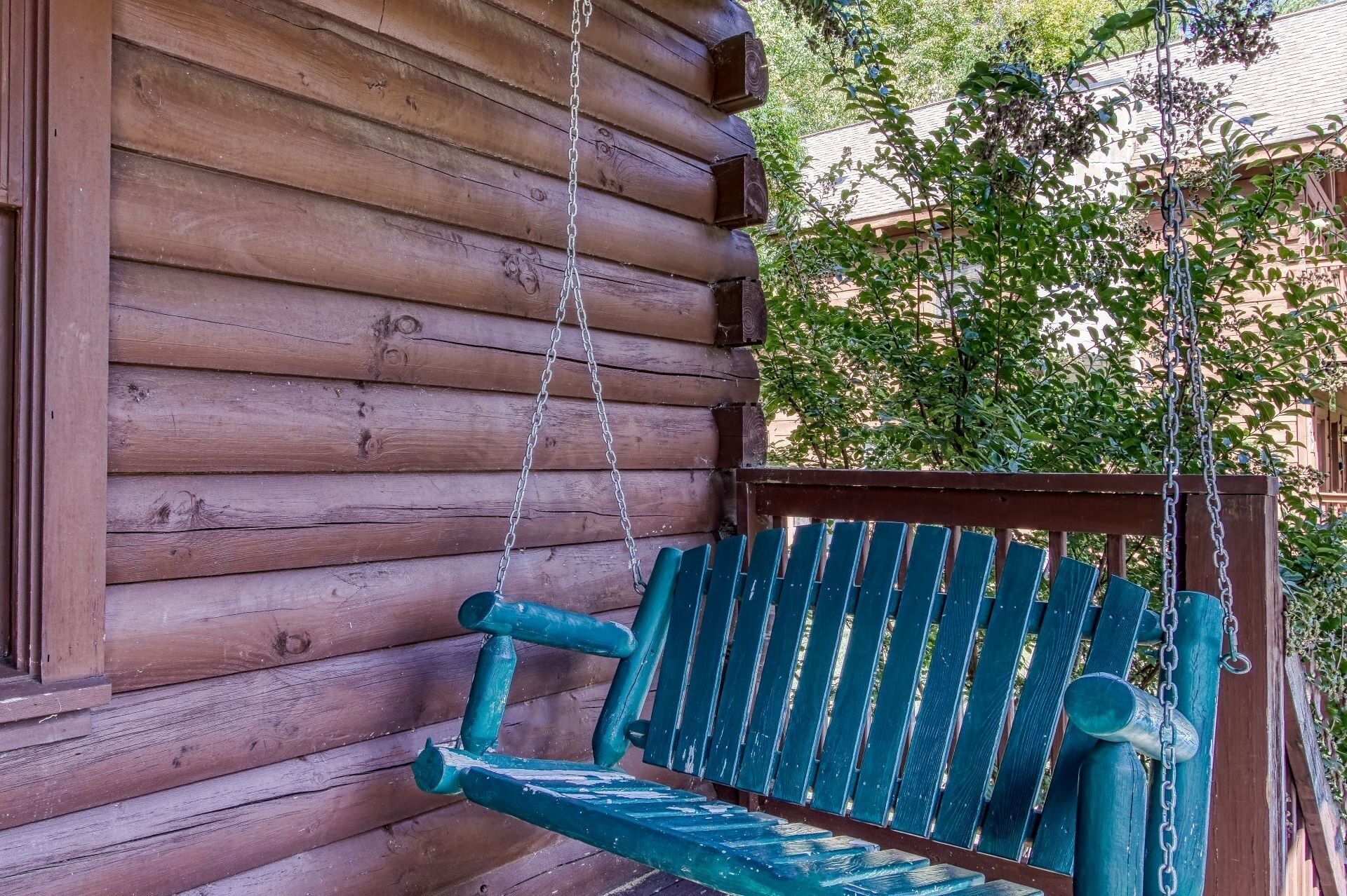 Eine Holzhütte mit Veranda und Schaukelstuhl.