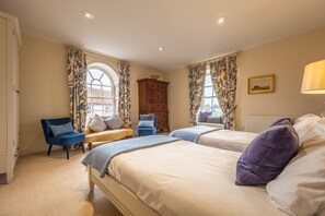 A bedroom with two beds, a dresser, a chair, and a window with curtains. - Alice House, Burnham Market, Norfolk (Burnham Market)