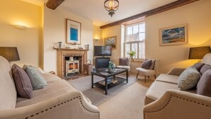 A cozy living room with a fireplace, comfortable seating, and a television. - Alice House, Burnham Market, Norfolk (Burnham Market)