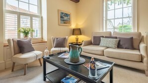 A cozy living room with a sofa, armchairs, a coffee table, and a lamp. - Alice House, Burnham Market, Norfolk (Burnham Market)