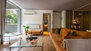 A modern living room with a glass coffee table, a sofa, and a view of the outdoors. - Phaedrus Living Luxury Flat Vouliagmeni (Vari-Voula-Vouliagmeni)