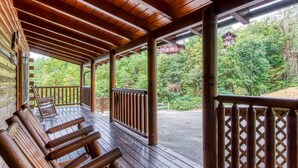 A wooden deck with benches, a railing, and a view of a forested area. - Ern807 - Black Bearry Ridge - Great Location! Close To All The Action! 6 Bedroom Cabin by RedAwning (Sevierville)