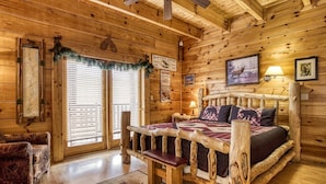 A log cabin bedroom with a wooden bed, a bench, a map, and a framed picture on the wall. - Ern854 - Wagon Wheel Lodge - Great Location! Close To All The Action! 9 Bedroom Cabin by RedAwning (Pigeon Forge)