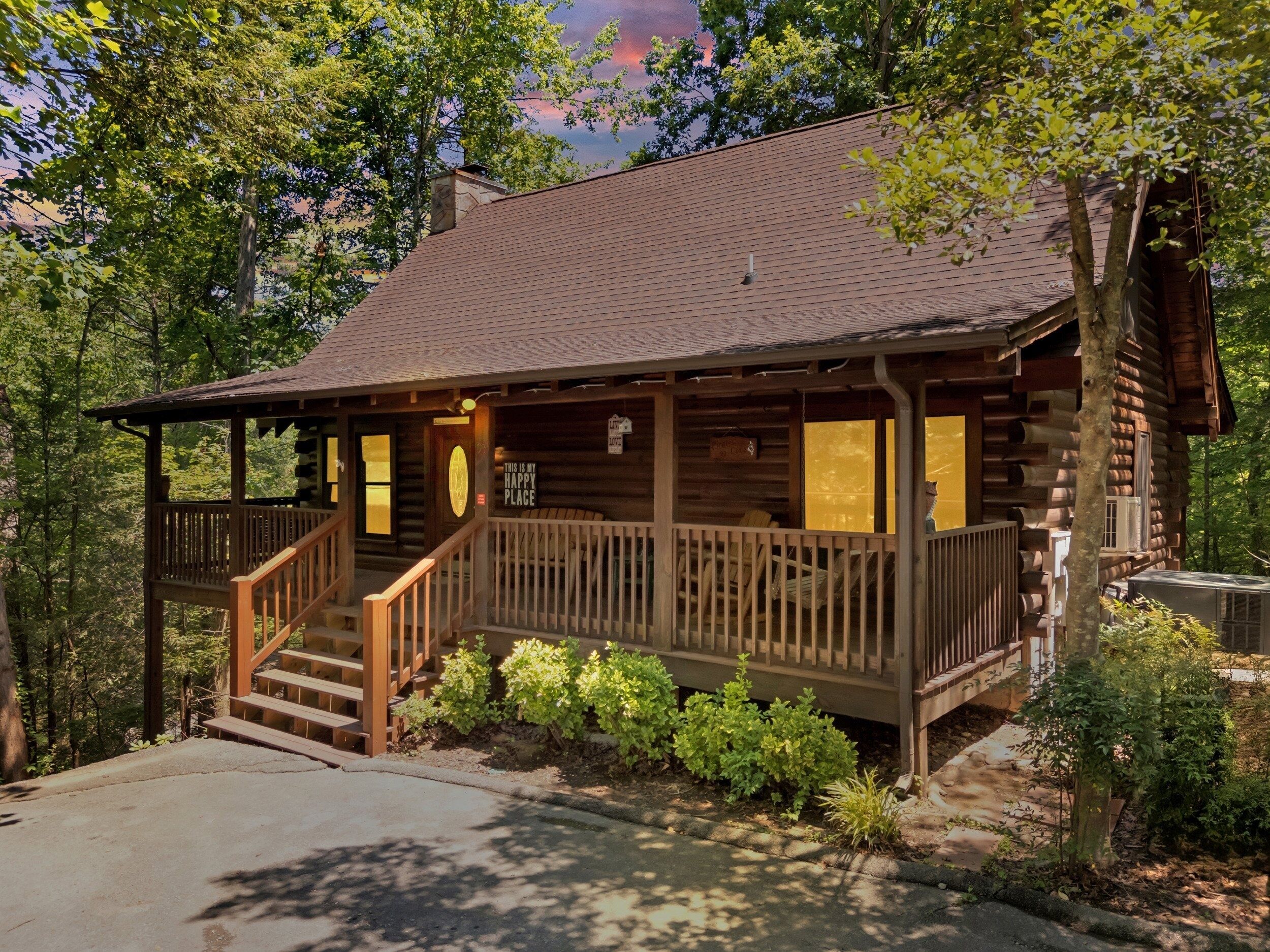 Eine Blockhütte mit Veranda, einer Treppe und einem Schild, auf dem steht: "Das ist mein glücklicher Ort."