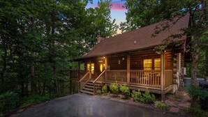 Eine rustikale Holzhütte mit einer Holzterrasse und einer Treppe zum Eingang.