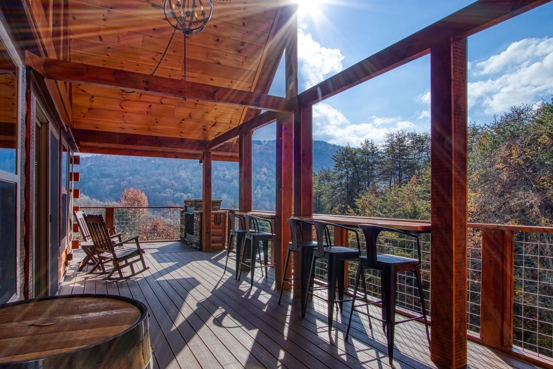 A wooden deck with outdoor seating and a view of mountains.
