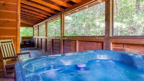 A wooden cabin with a hot tub, large windows, and a deck area. - Er 229 Brief Escape - Great Location Close to Town - 4 BR Cabin by RedAwning (Pigeon Forge)
