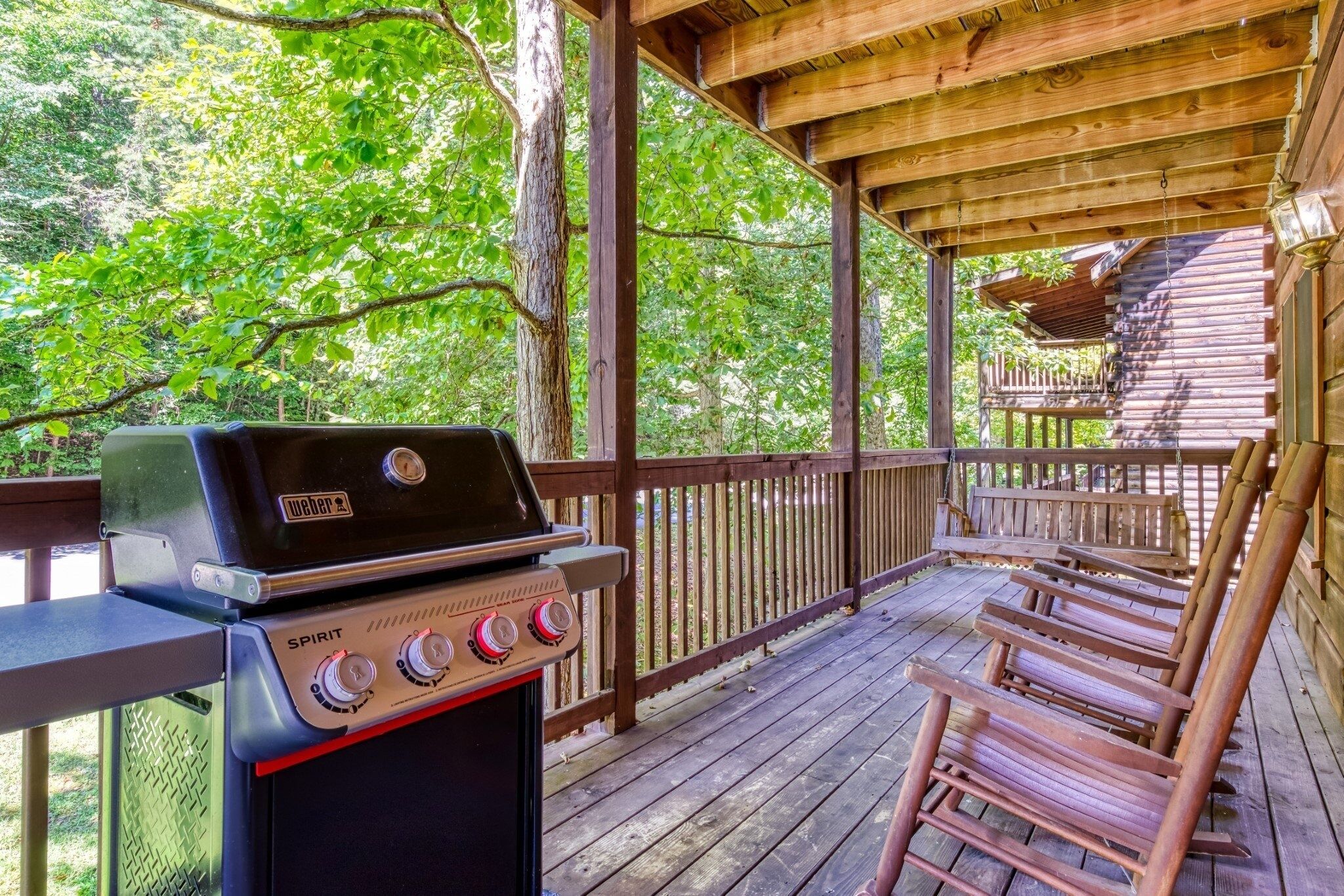 An outdoor wooden deck with a grill and seating area.