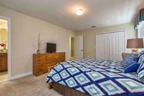 A bedroom with a bed, dresser, television, and a door leading to another room. - Paradise Palms-6 bedrooms House w-pool-3509PP 6 Home by RedAwning (Kissimmee)