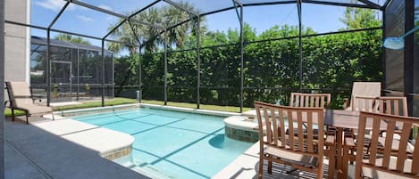 Ein überdachter Außenpool mit Terrassenbereich, inklusive Tisch und Stühlen.