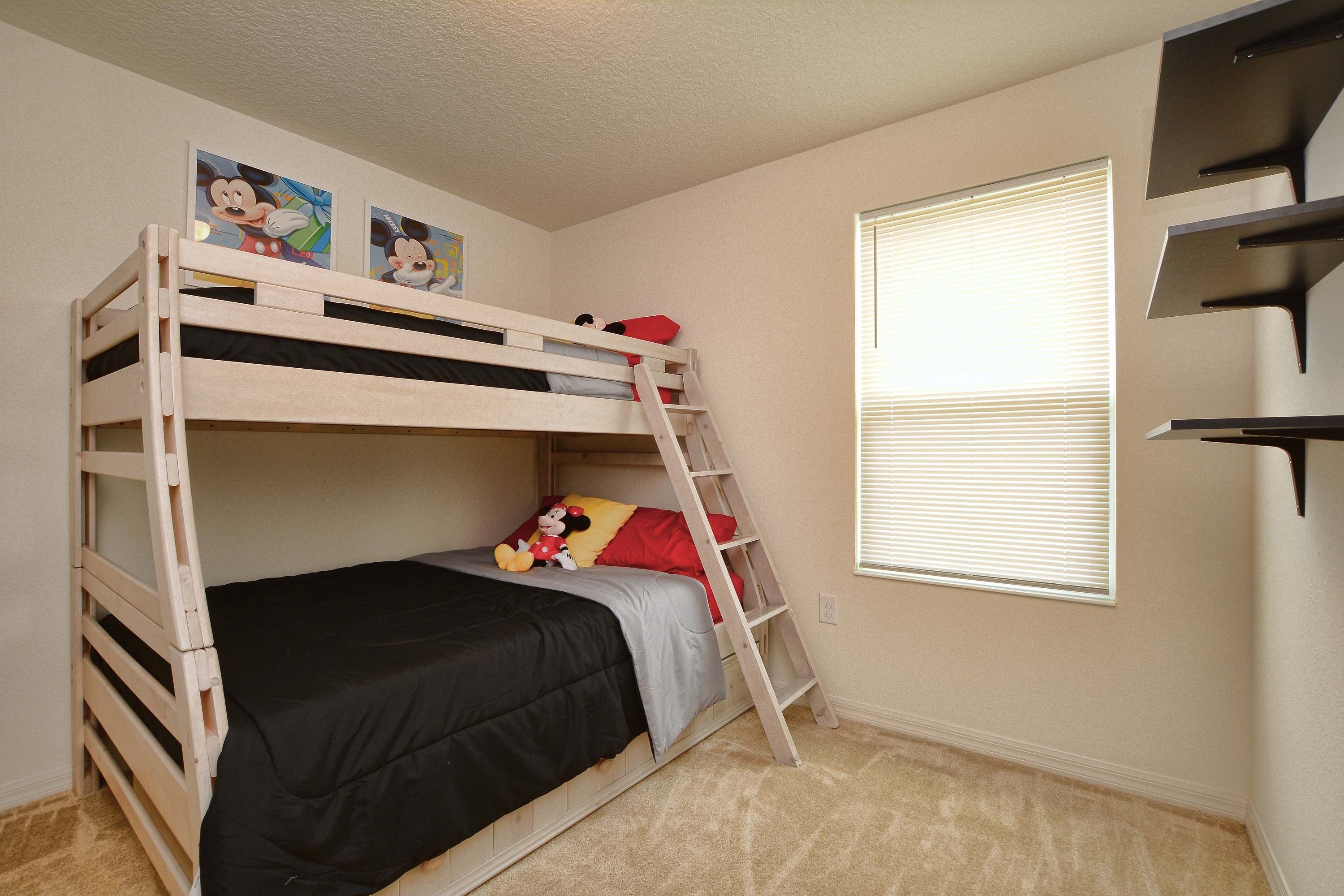 A bunk bed with a ladder, a window with blinds, and a wall with two Mickey Mouse posters.