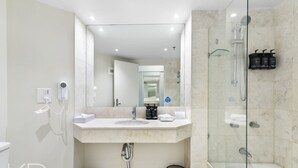 A modern bathroom with a large mirror, a sink, a shower, and a toilet. - Surfers Paradise Beach & Ocean View Unit (Level 7) (Surfers Paradise)