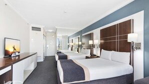 A hotel room with two beds, a desk with a TV, and a balcony with a view. - Surfers Paradise Beach & Ocean View Unit (Level 7) (Surfers Paradise)