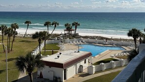 A pool area with a view of the ocean, palm trees, and a gazebo. - 451 El Matador 2 Bedroom Condo by RedAwning (Fort Walton Beach)