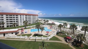 A hotel with a pool, beach, and ocean view.